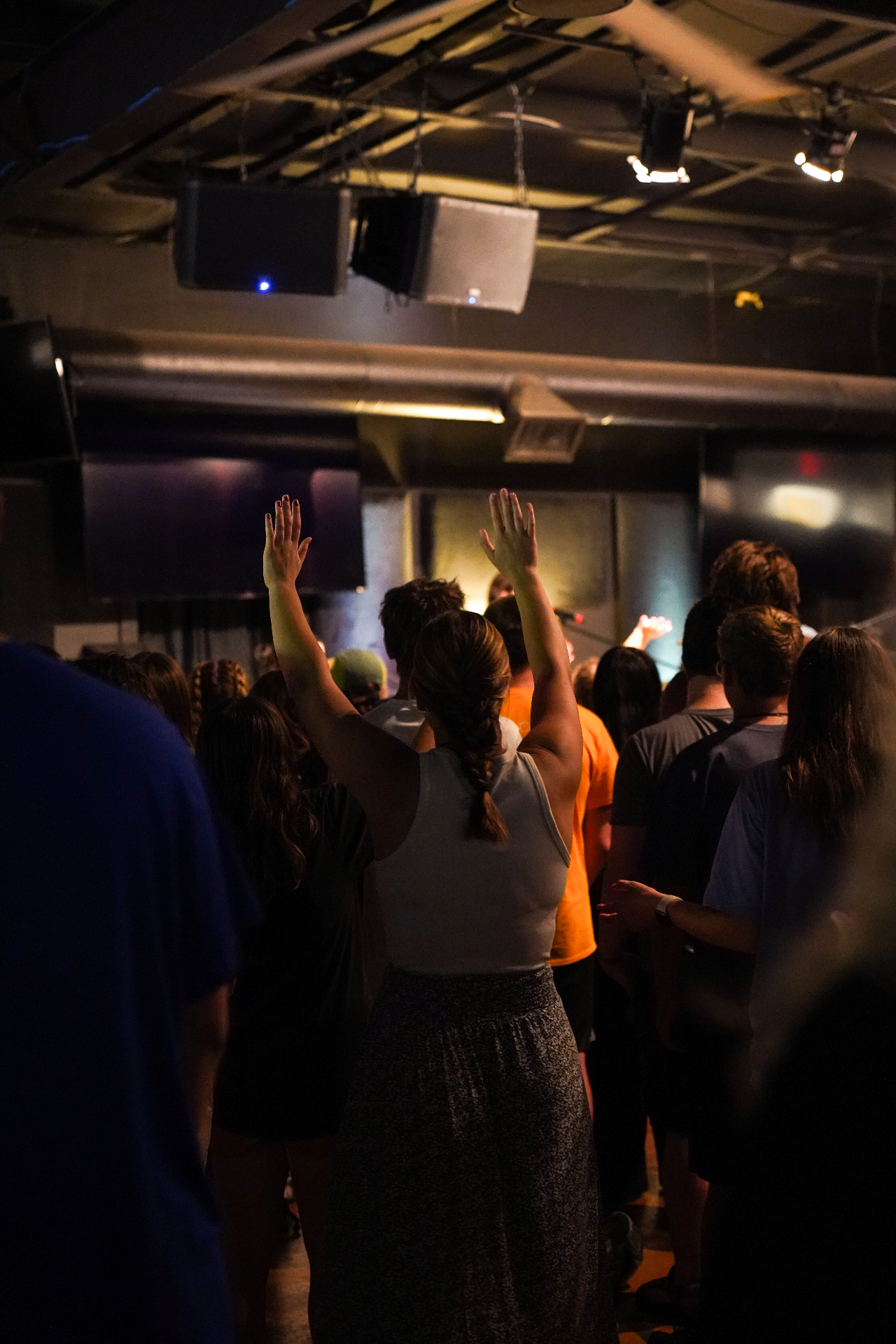 A racer worshipping with hands raised during a training camp session
