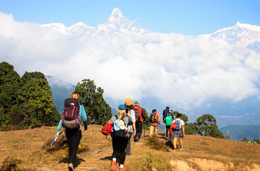 Racers trekking toward the snow-capped Himalayas in Nepal