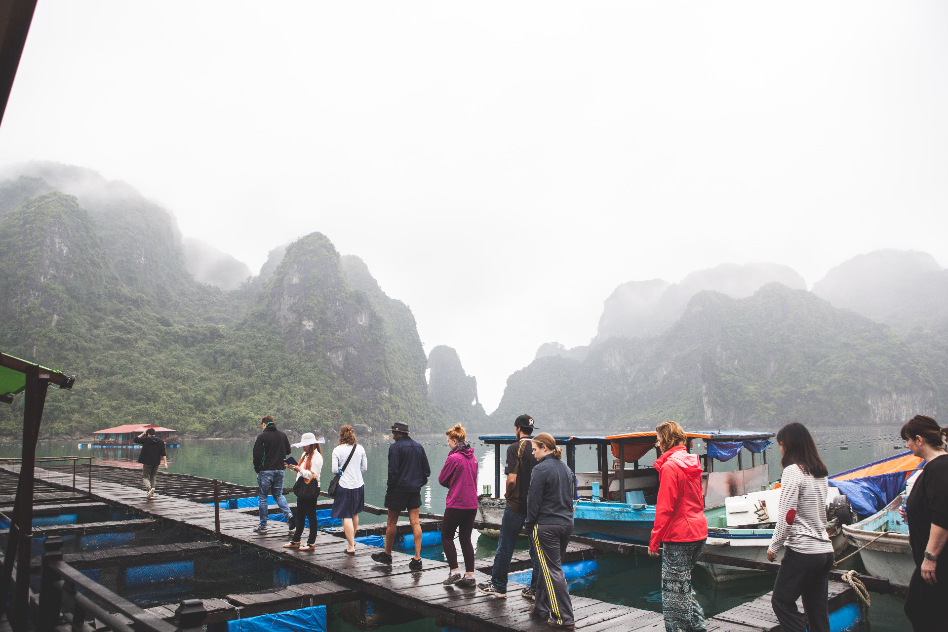 Racers walking along floating docks in Vietnam's misty Ha Long Bay