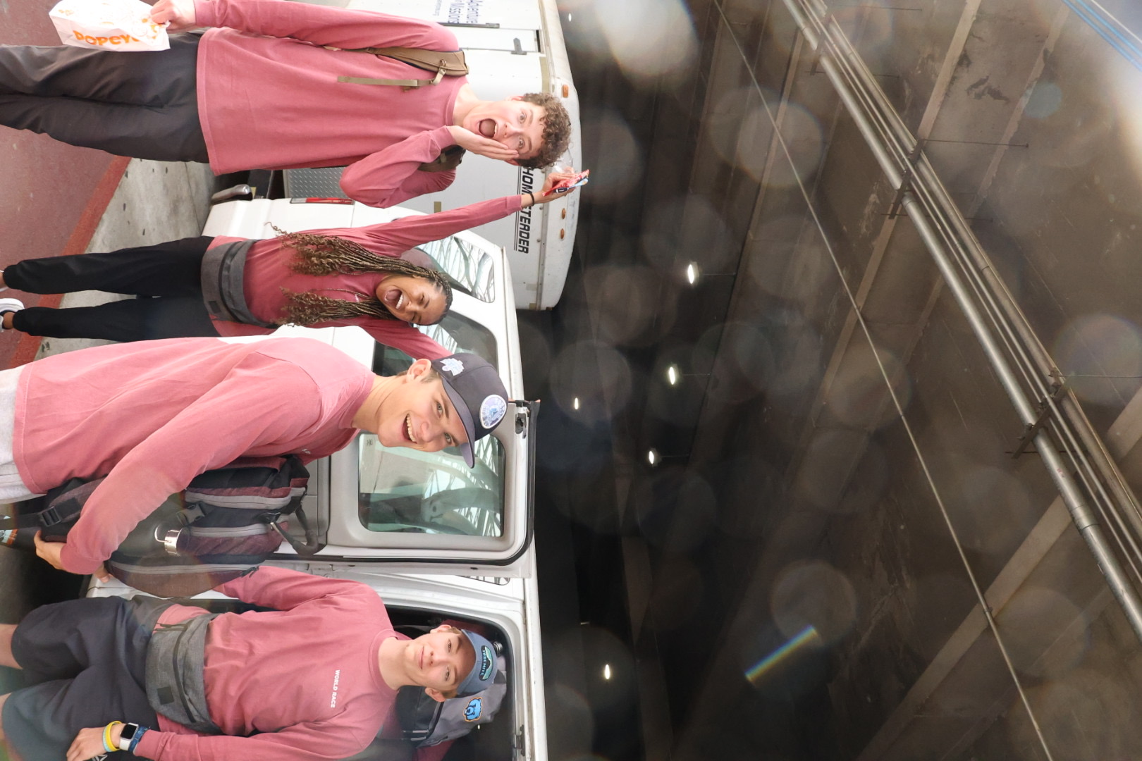 Racers in matching shirts celebrating by the vans before heading out