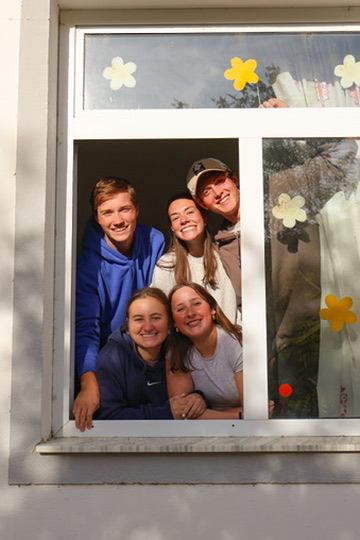 Racers smiling through a flower-decorated window in Albania