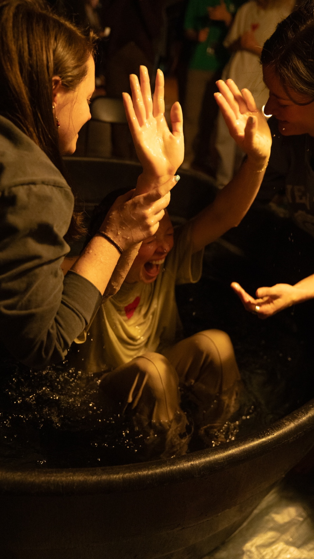 A racer coming up out of the water at a baptism, arms lifted