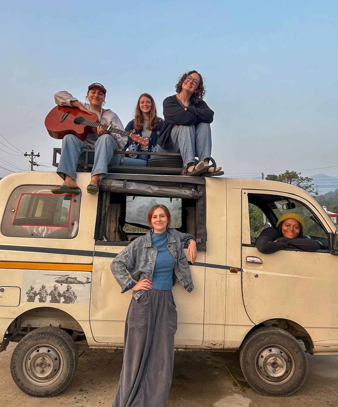 Racers gathered on top of a van at sunset in Nepal