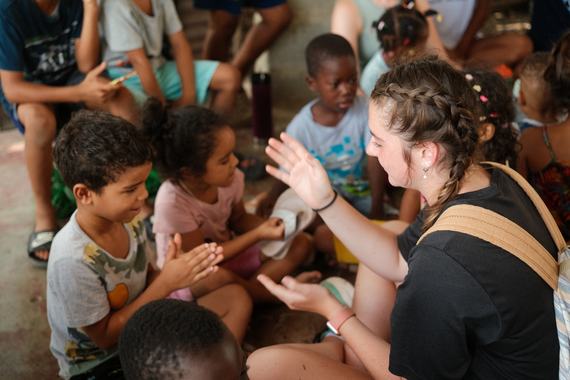 World Race participant clapping with children in the Dominican Republic