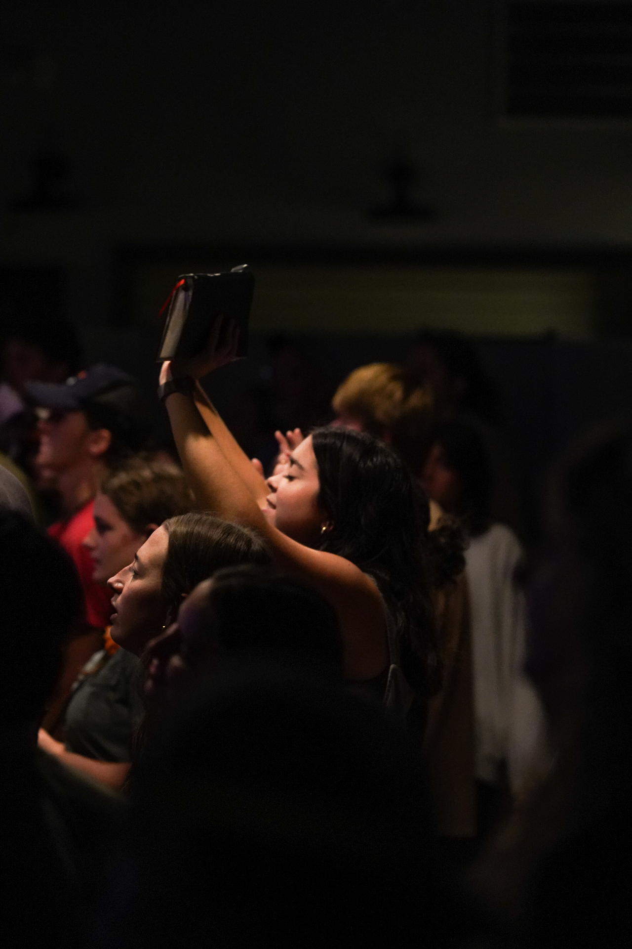 A racer holding up a Bible during worship at training camp