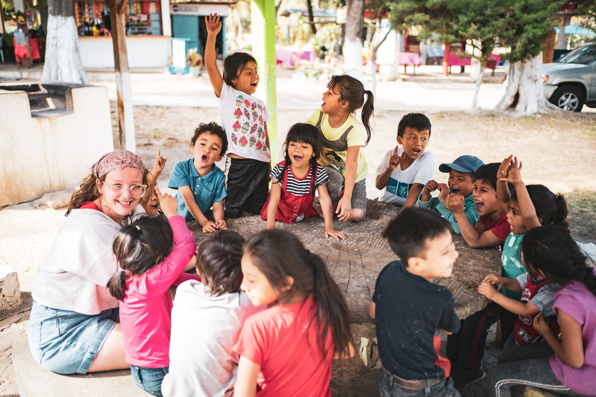 Racer gathered with Guatemalan children around a tree stump during ministry