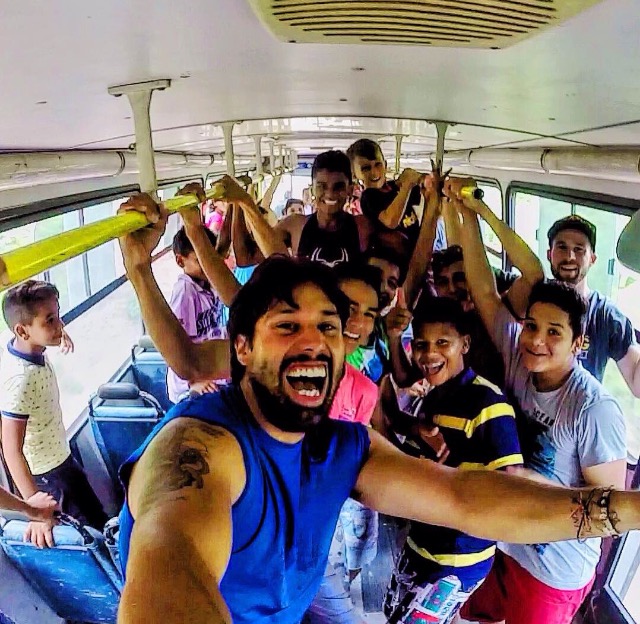 Racer with Brazilian kids on a bus