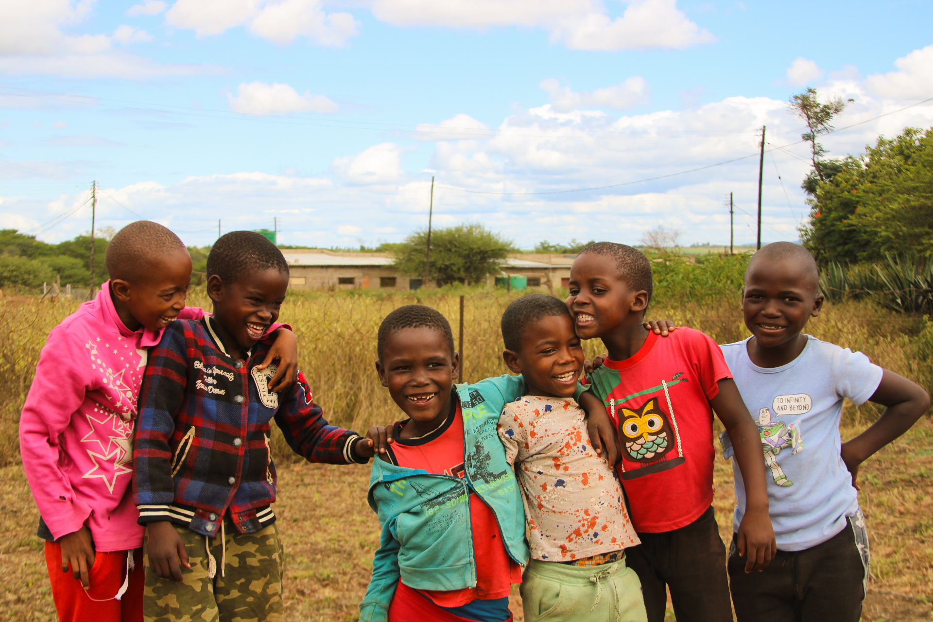 Group of smiling Eswatini children with arms around each other