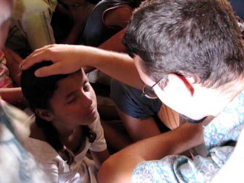 Racer praying over an Indian girl