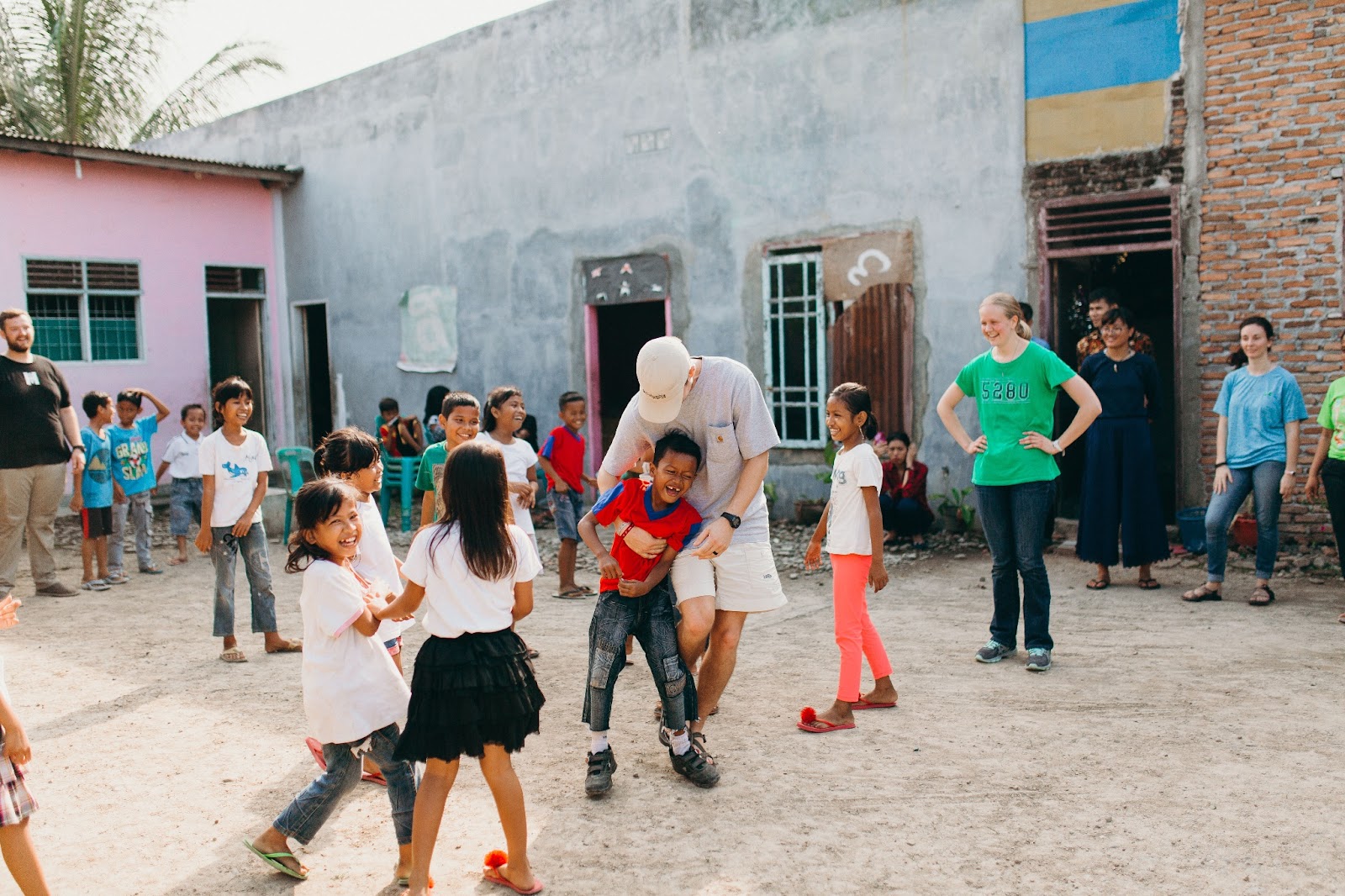 Racer playing with Indonesian children in a village courtyard