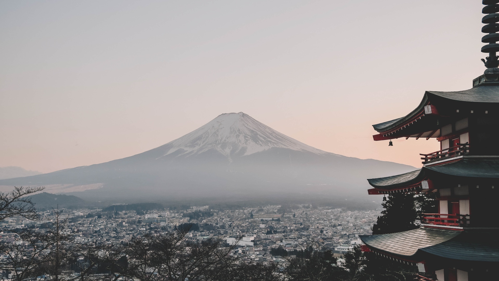 Mount Fuji at sunrise with a red pagoda overlooking the city