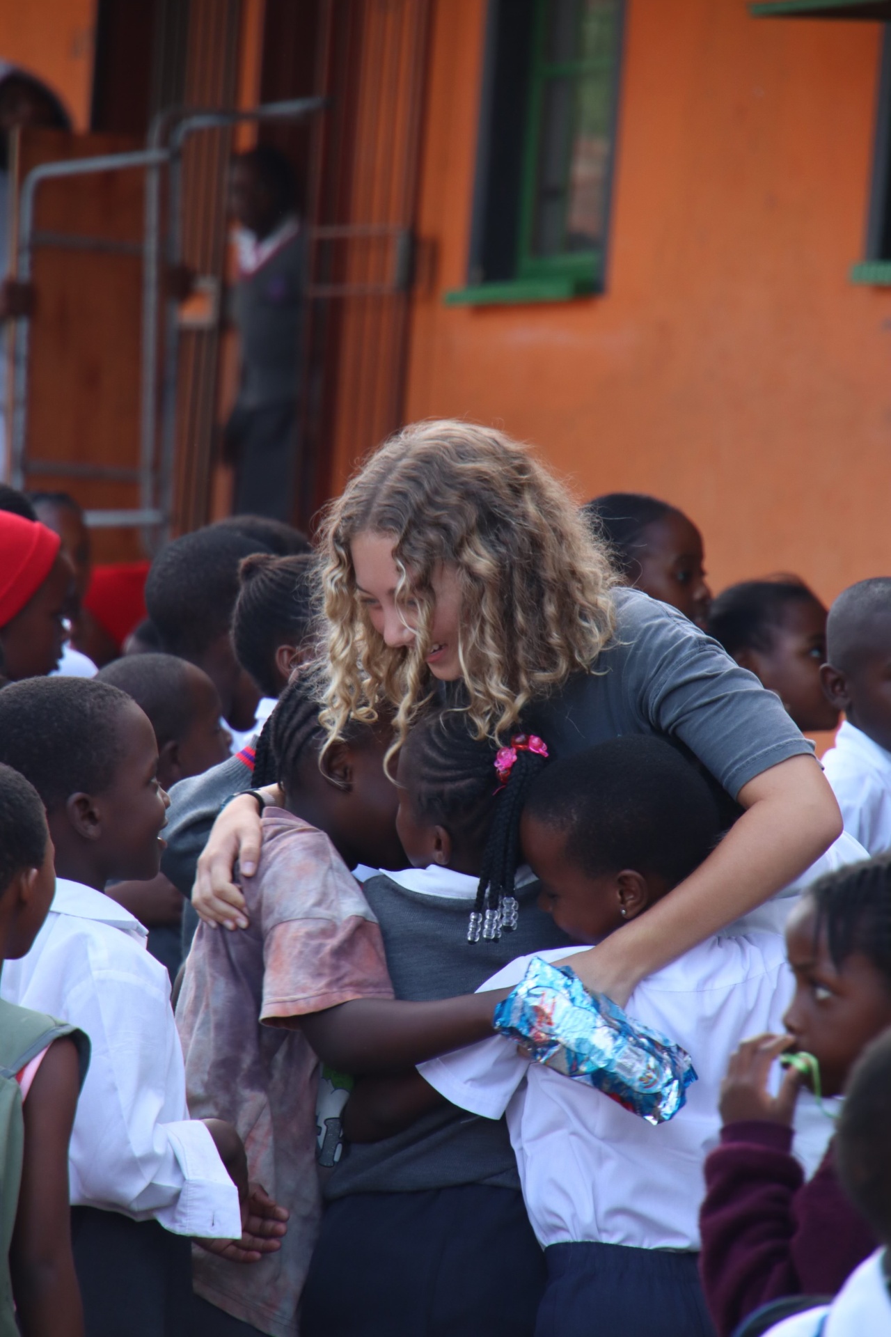 Racer being hugged by South African schoolchildren