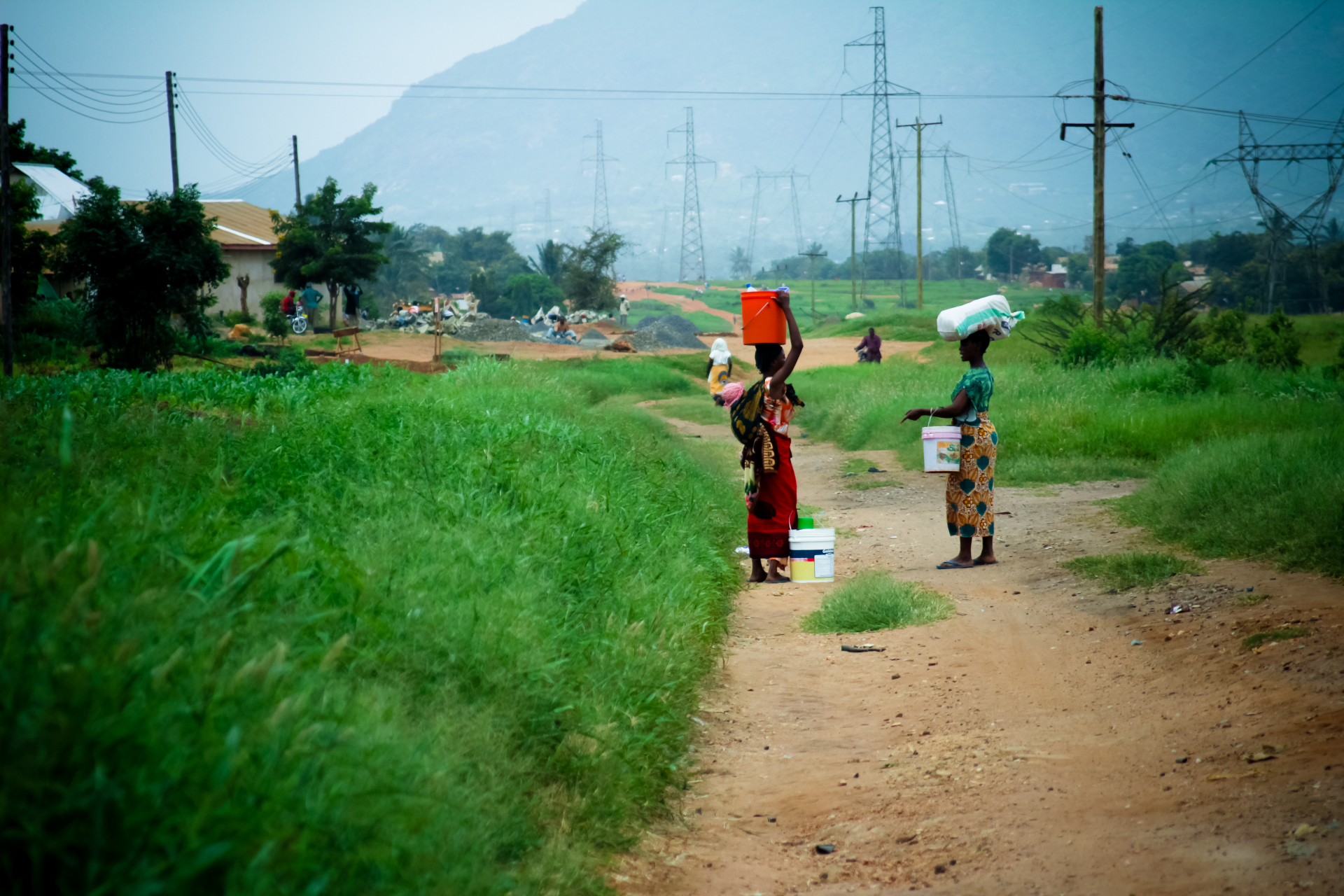 Tanzanian women carrying water along a roadside